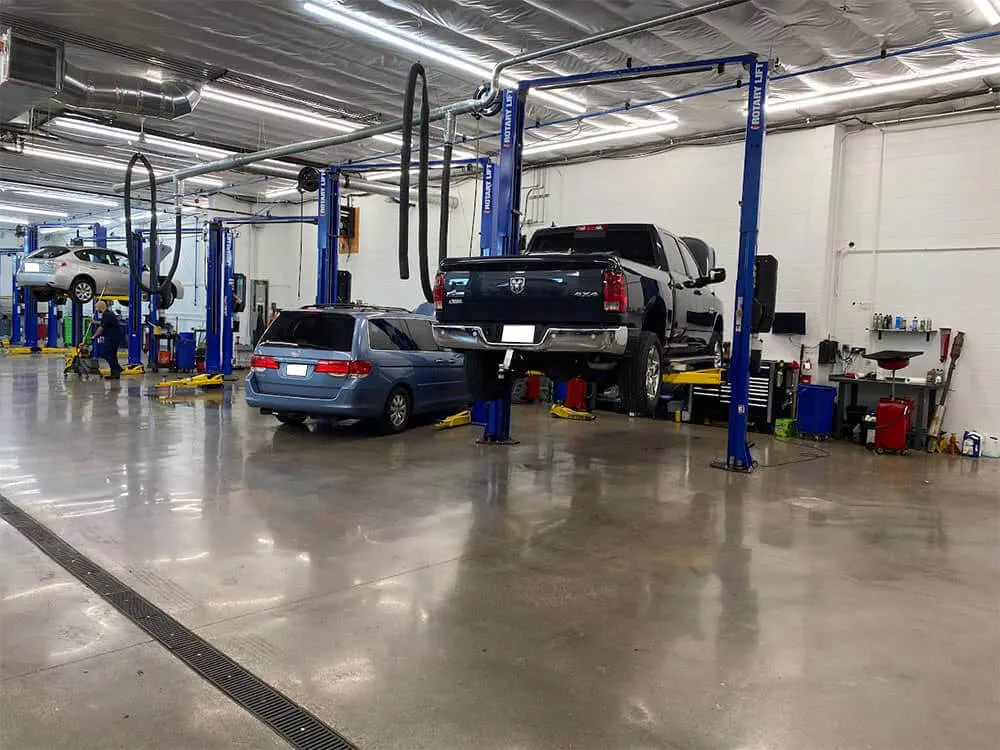 Cars on lifts in auto repair shop.