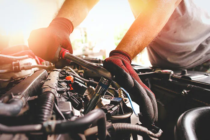 Mechanic working on engine with wrench